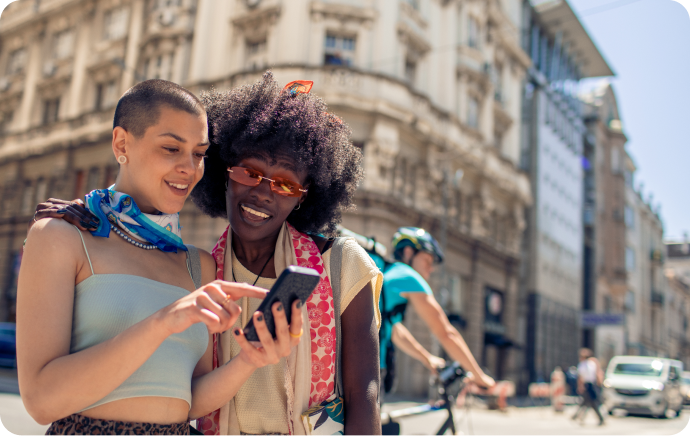 Two woman smiling and looking at a phone together